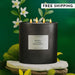 Black candle labeled 'Neroli Ylang Bergamot' with floral elements on a green background