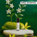 Perfume bottle with flowers and greenery on a dark green background