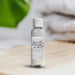 Small bottle of Marine Bergamot Jasmine fragrance oil on a wooden surface with a blurred natural background